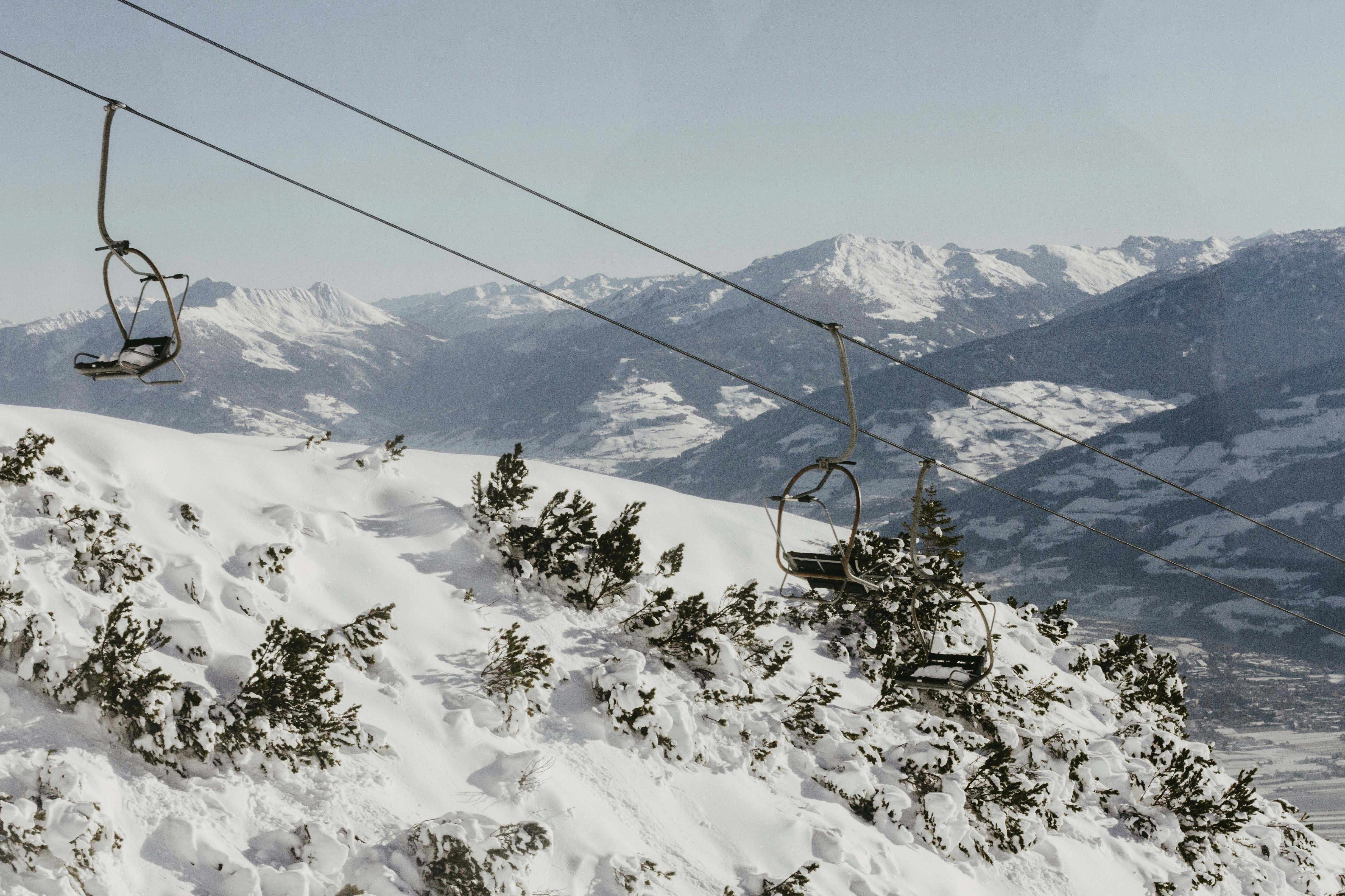 a ski lift going up the side of a snow covered mountain