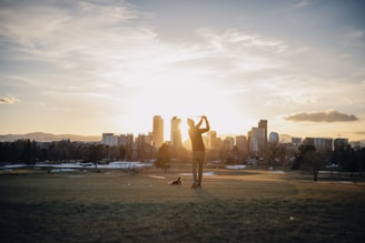 a person standing in a field with a city in the background