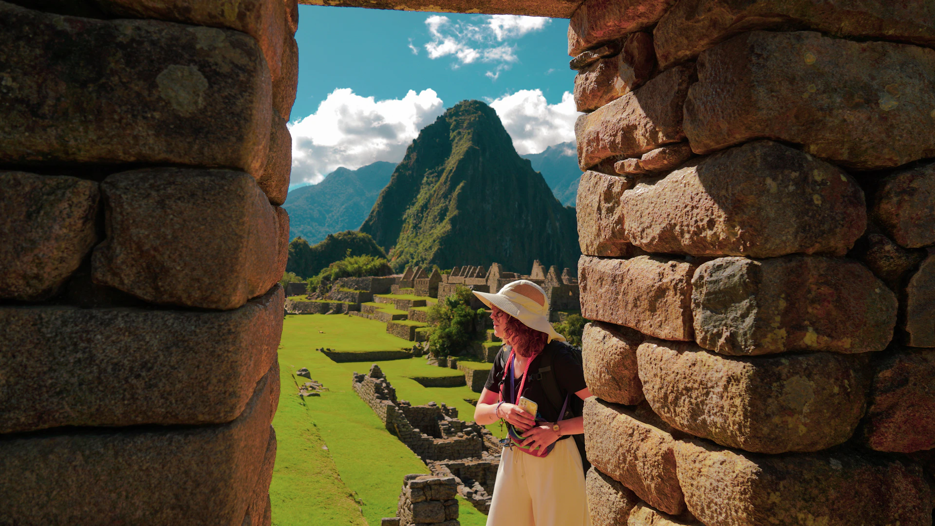 a woman in a straw hat looking out of a window