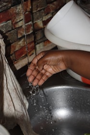 a person washing their hands in a sink