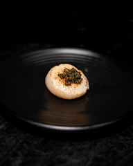 a black plate with a piece of food on it