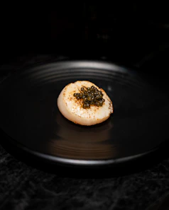 a black plate with a piece of food on it