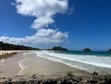 a sandy beach with waves coming in to shore