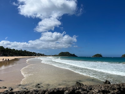 a sandy beach with waves coming in to shore