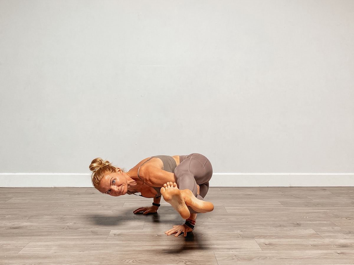 Instruktur yoga melakukan pose keseimbangan lengan tingkat lanjut sebagai contoh kontrol tubuh seperti crab walk di Primal Movement Challenge