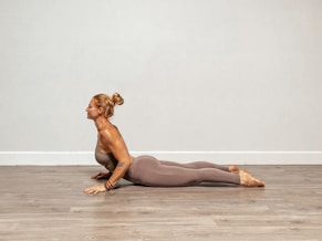 a woman is doing a yoga pose on the floor