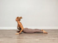 a woman is doing a yoga pose on the floor