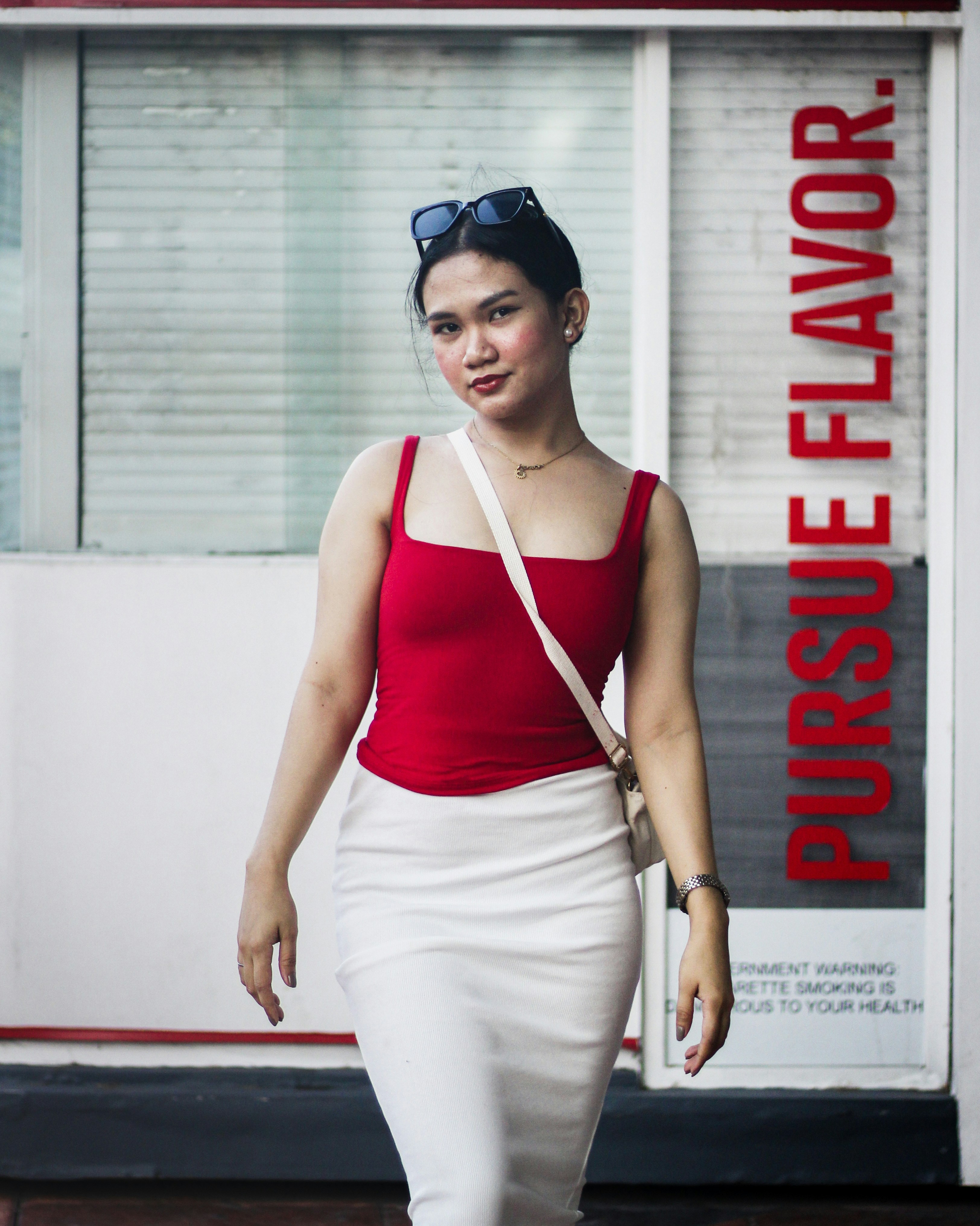 a woman in a red top and white skirt