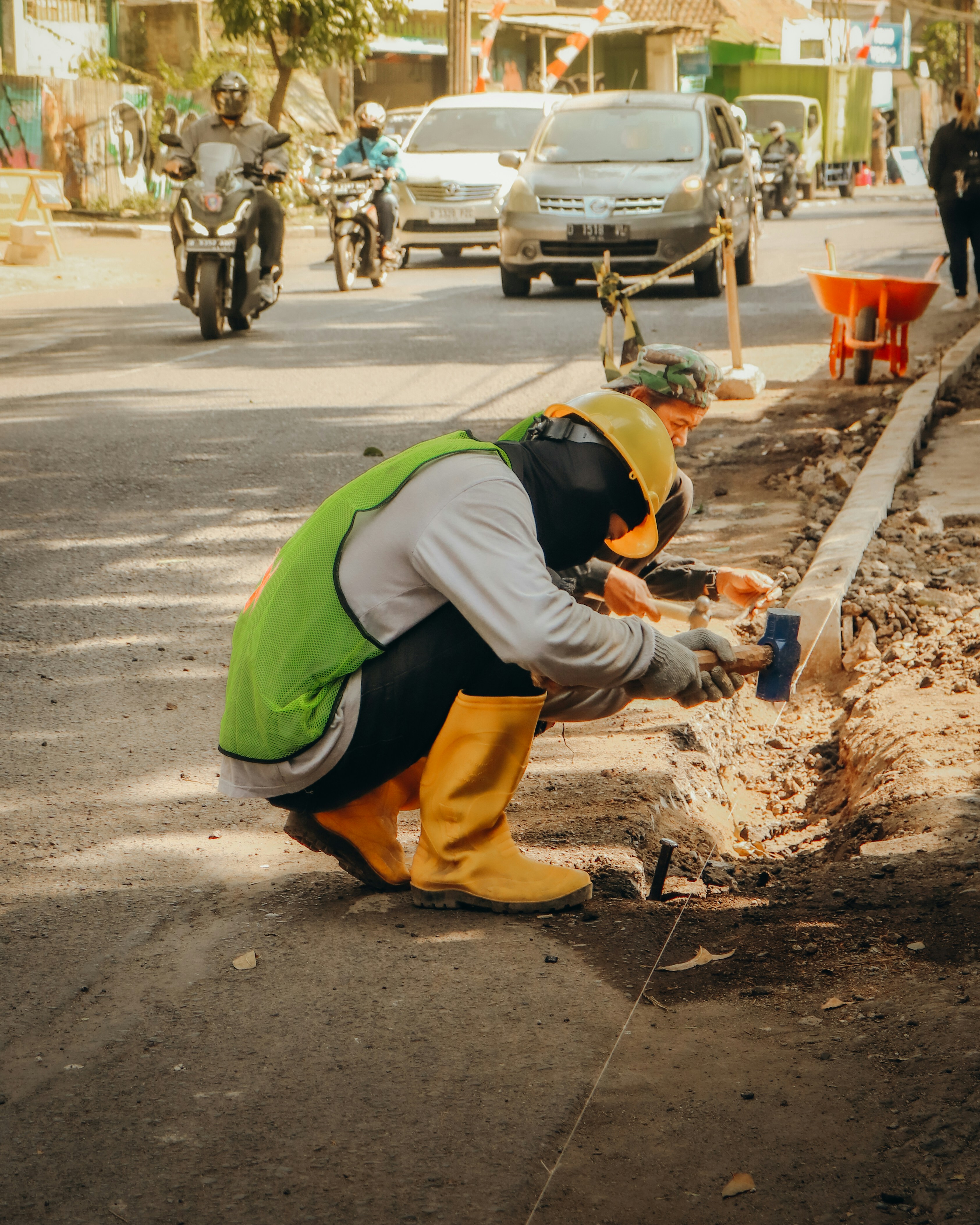 a man kneeling down next to a street
