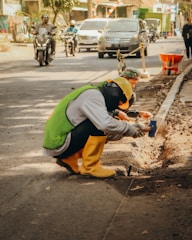 a man kneeling down next to a street