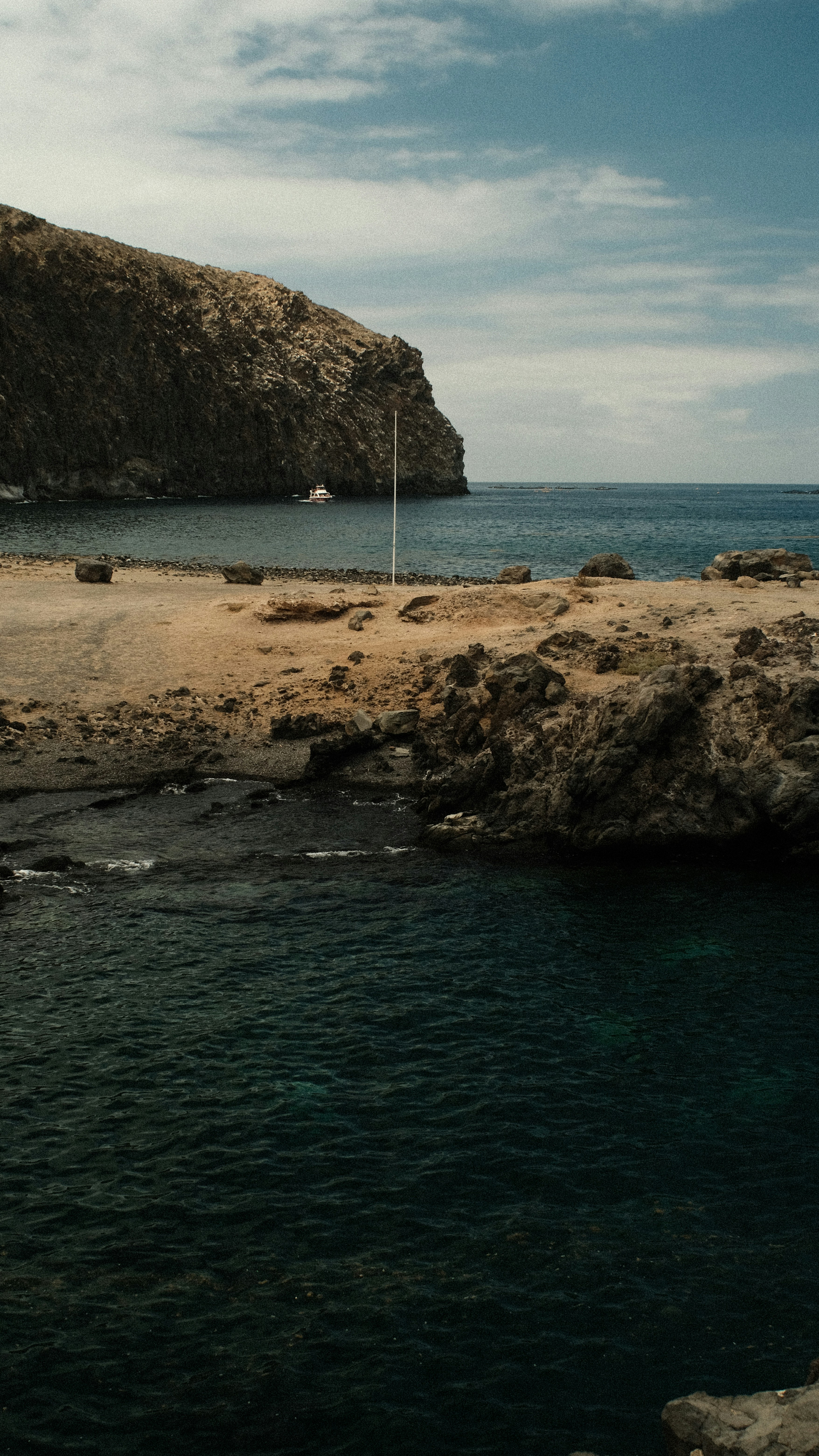 uno specchio d'acqua seduto vicino a una costa rocciosa