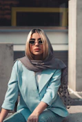 a woman sitting on the ground wearing sunglasses
