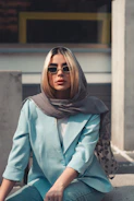 a woman sitting on the ground wearing sunglasses