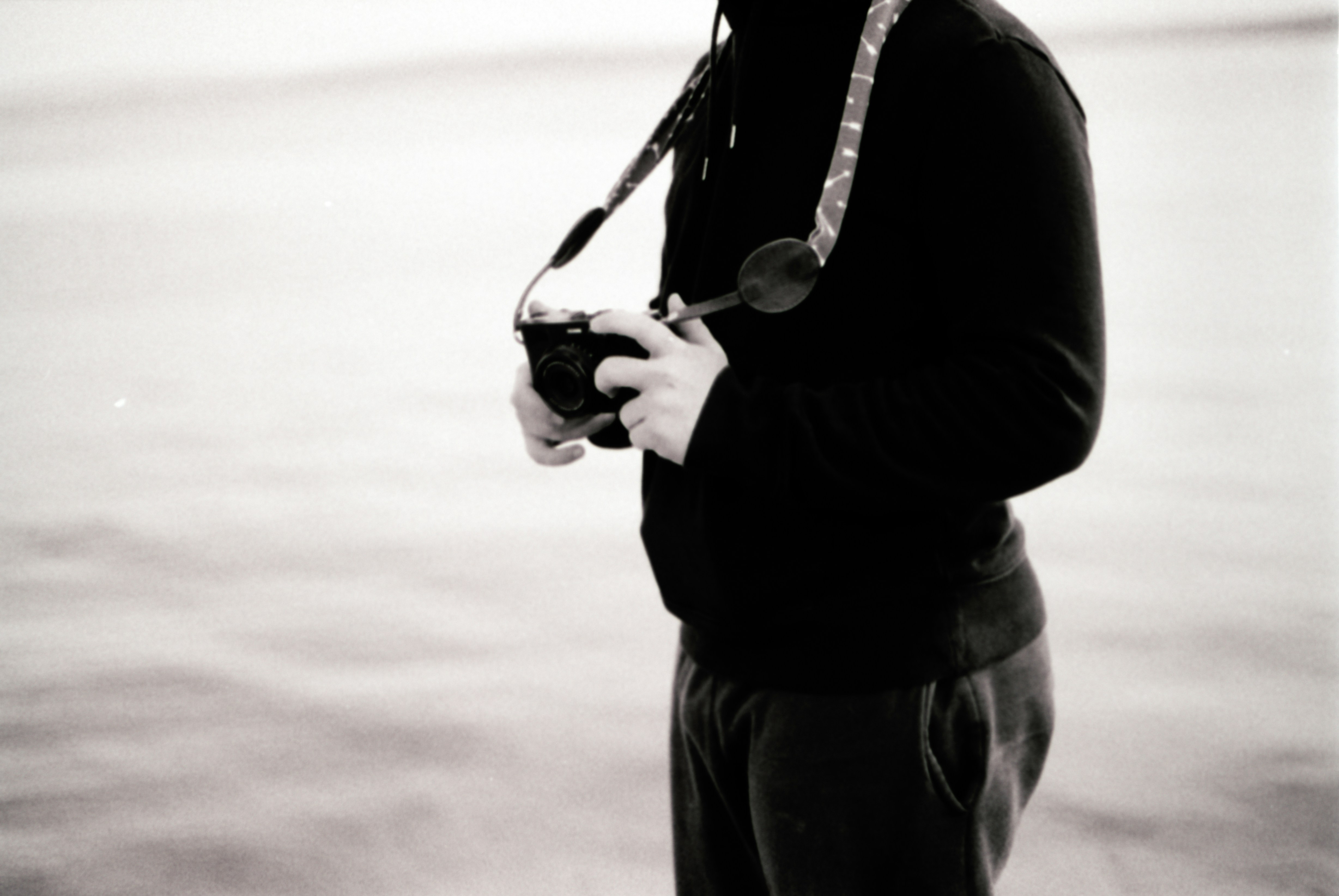 a black and white photo of a man holding a camera