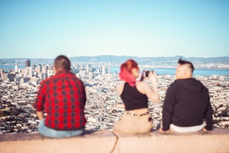 a couple of people sitting on top of a cement wall