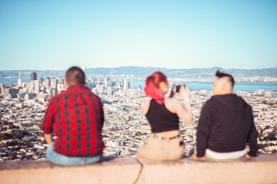 a couple of people sitting on top of a cement wall