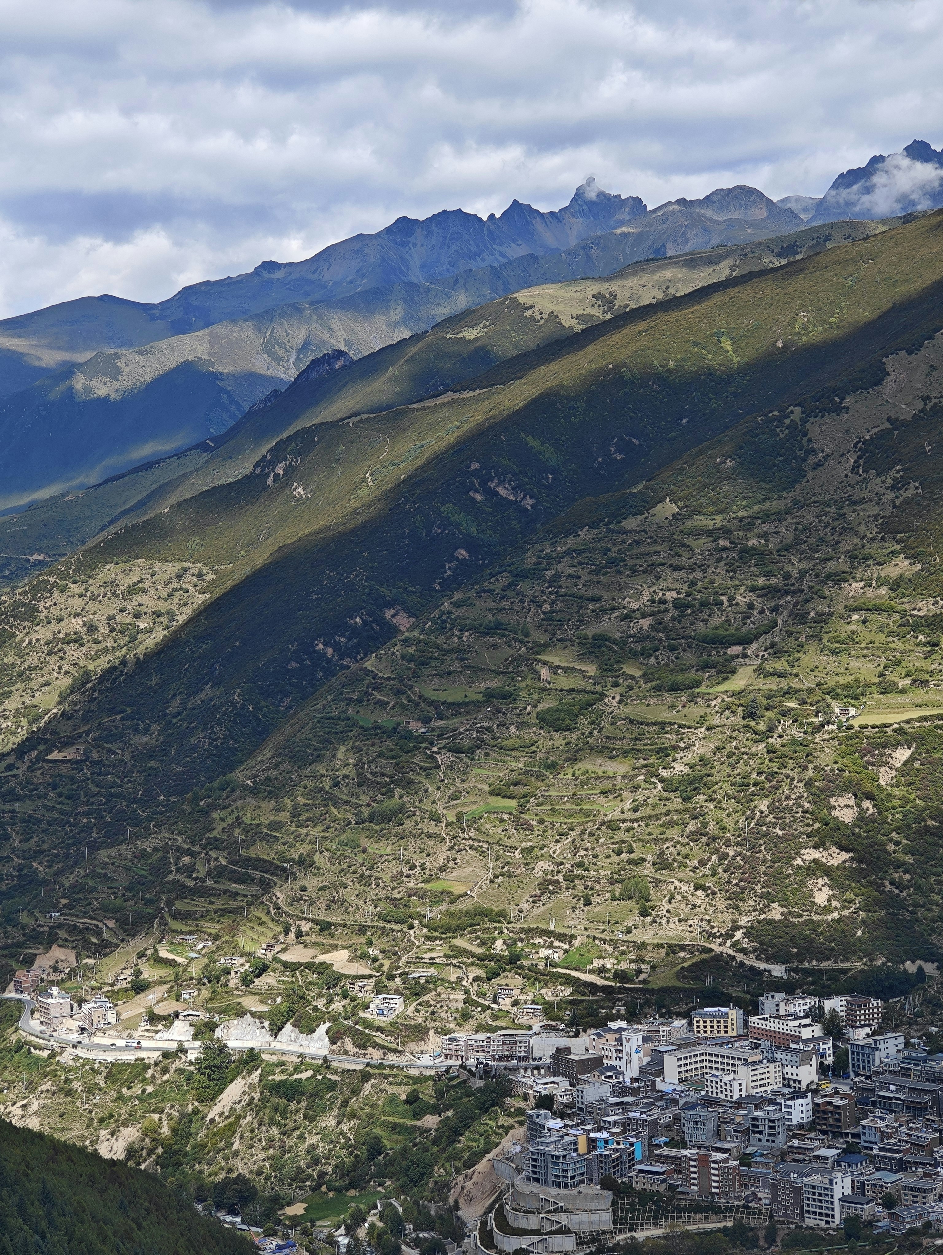 a scenic view of a city in the mountains