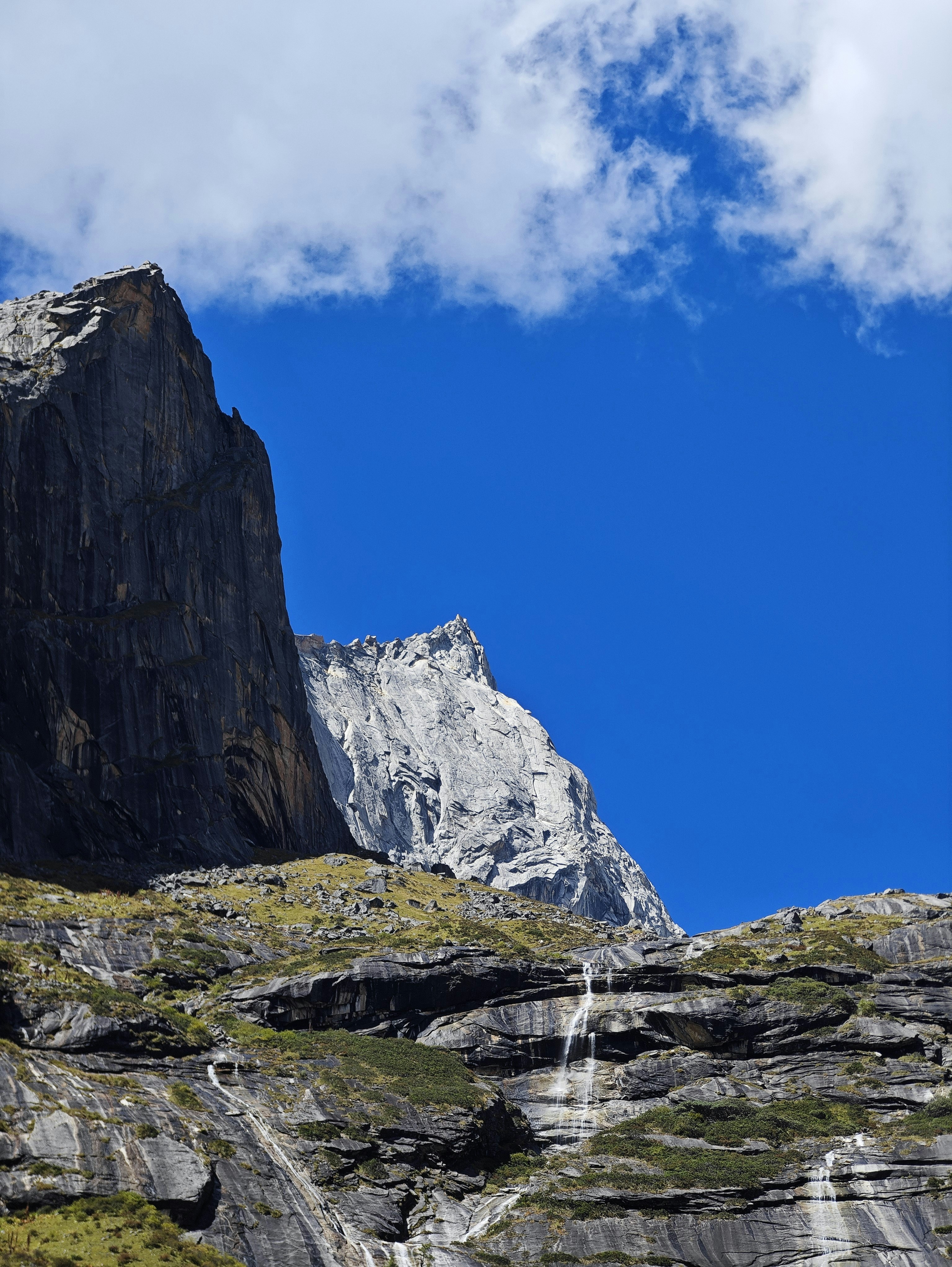 a tall mountain with a waterfall running down it's side