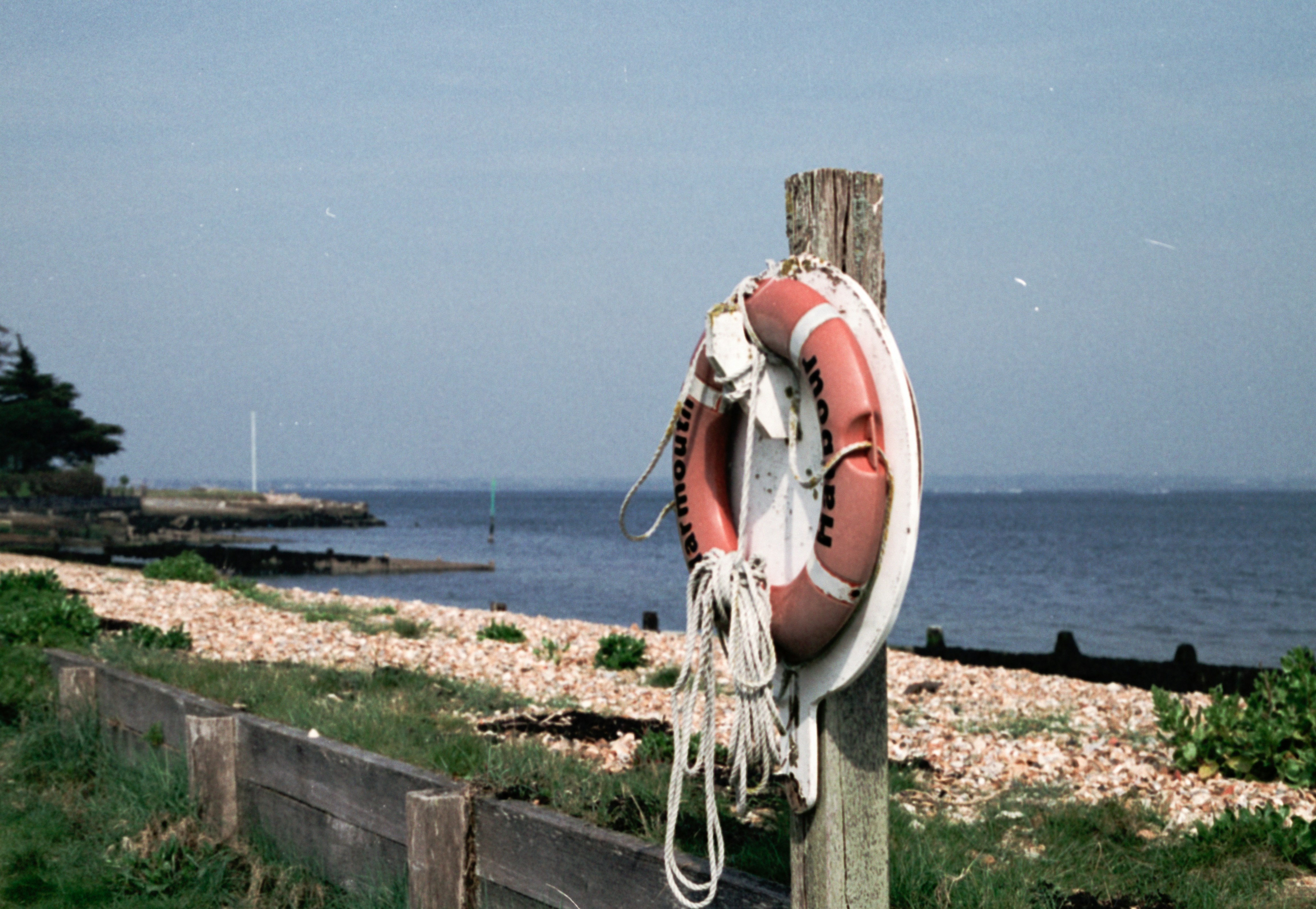 a life preserver on a wooden post near the ocean