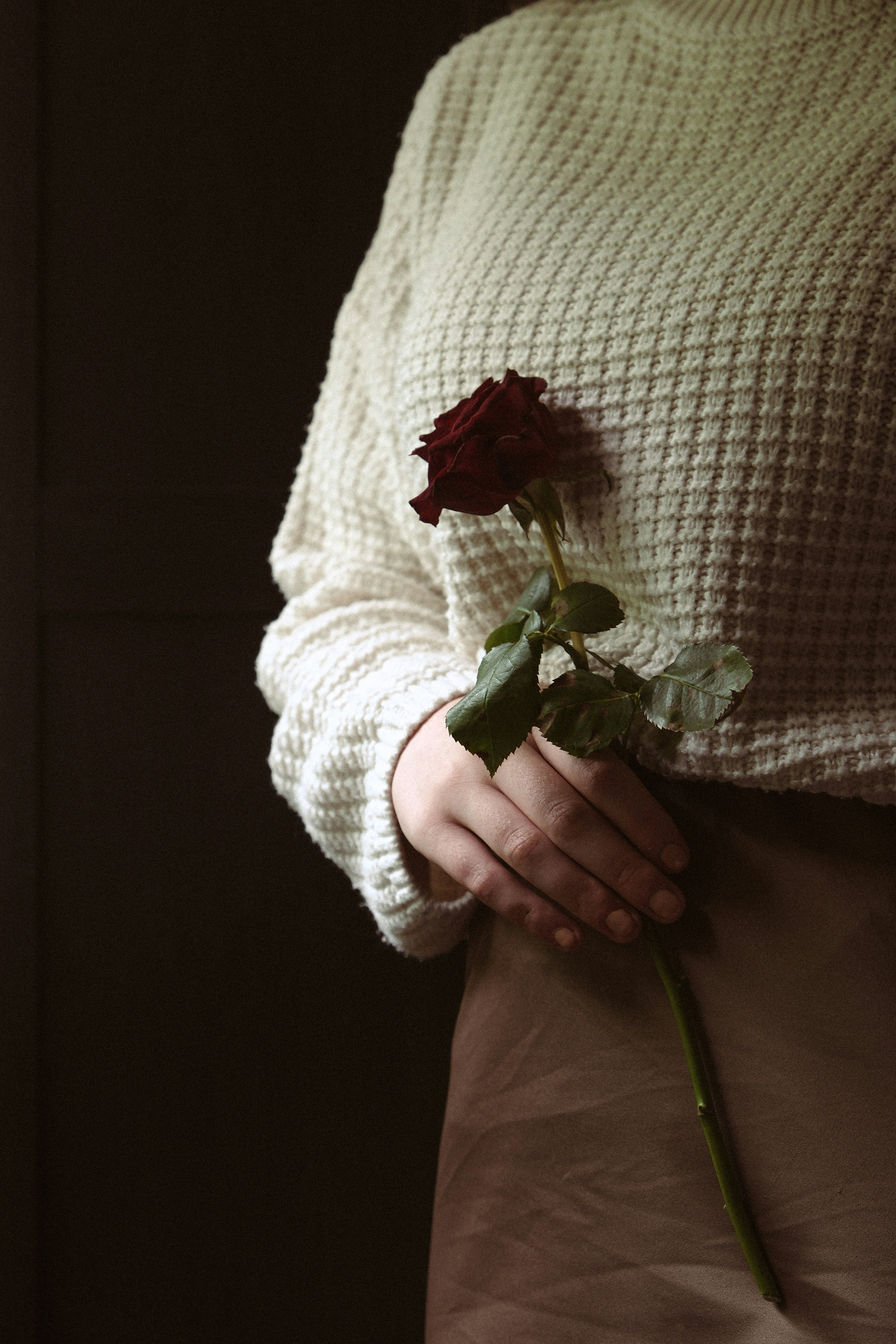 Eine Frau, die eine Rose in den Händen hält