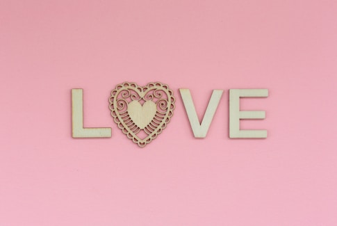 the word love spelled with a heart on a pink background