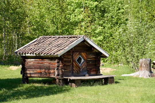 a log cabin with a bench in front of it