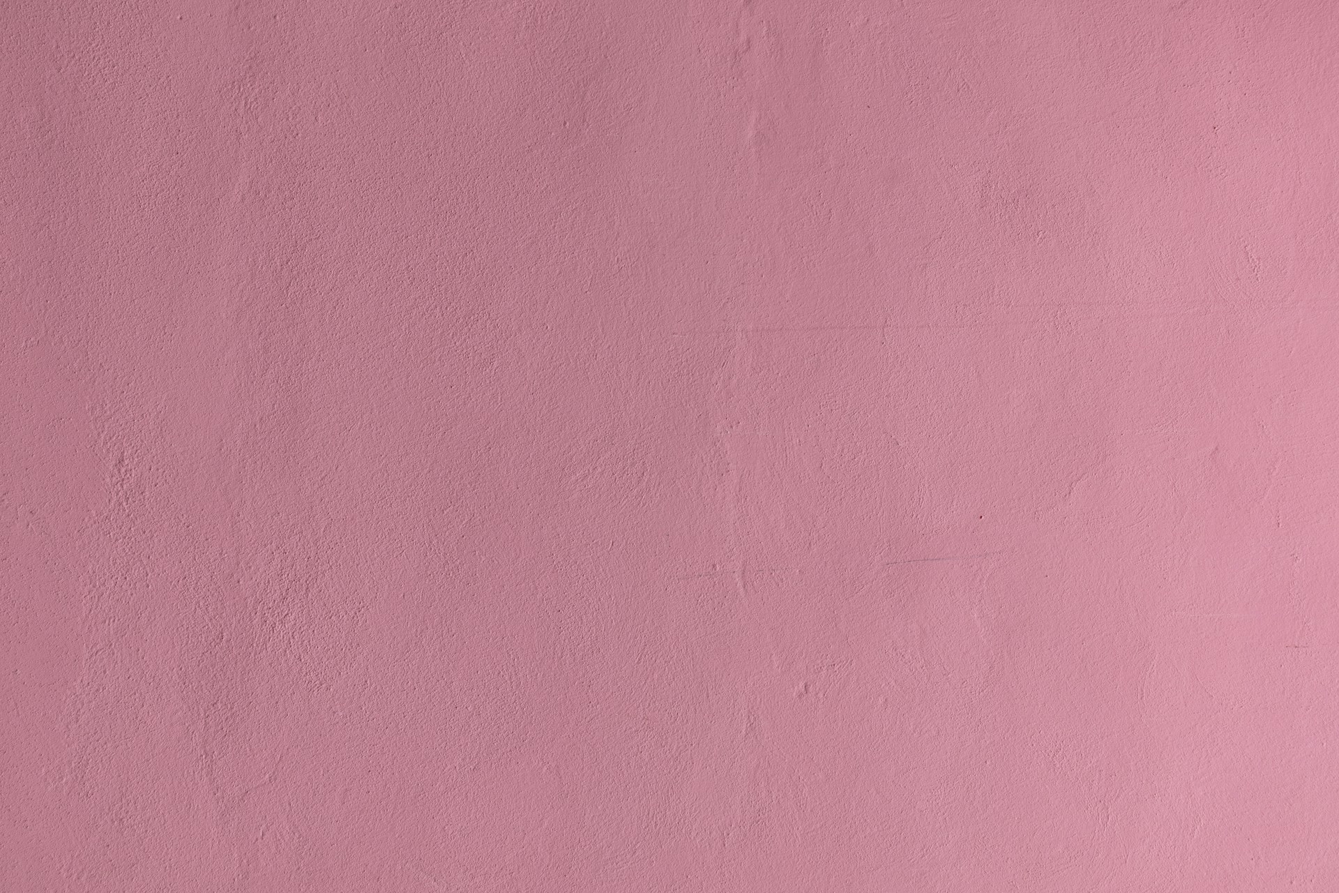a pink wall with a clock on it