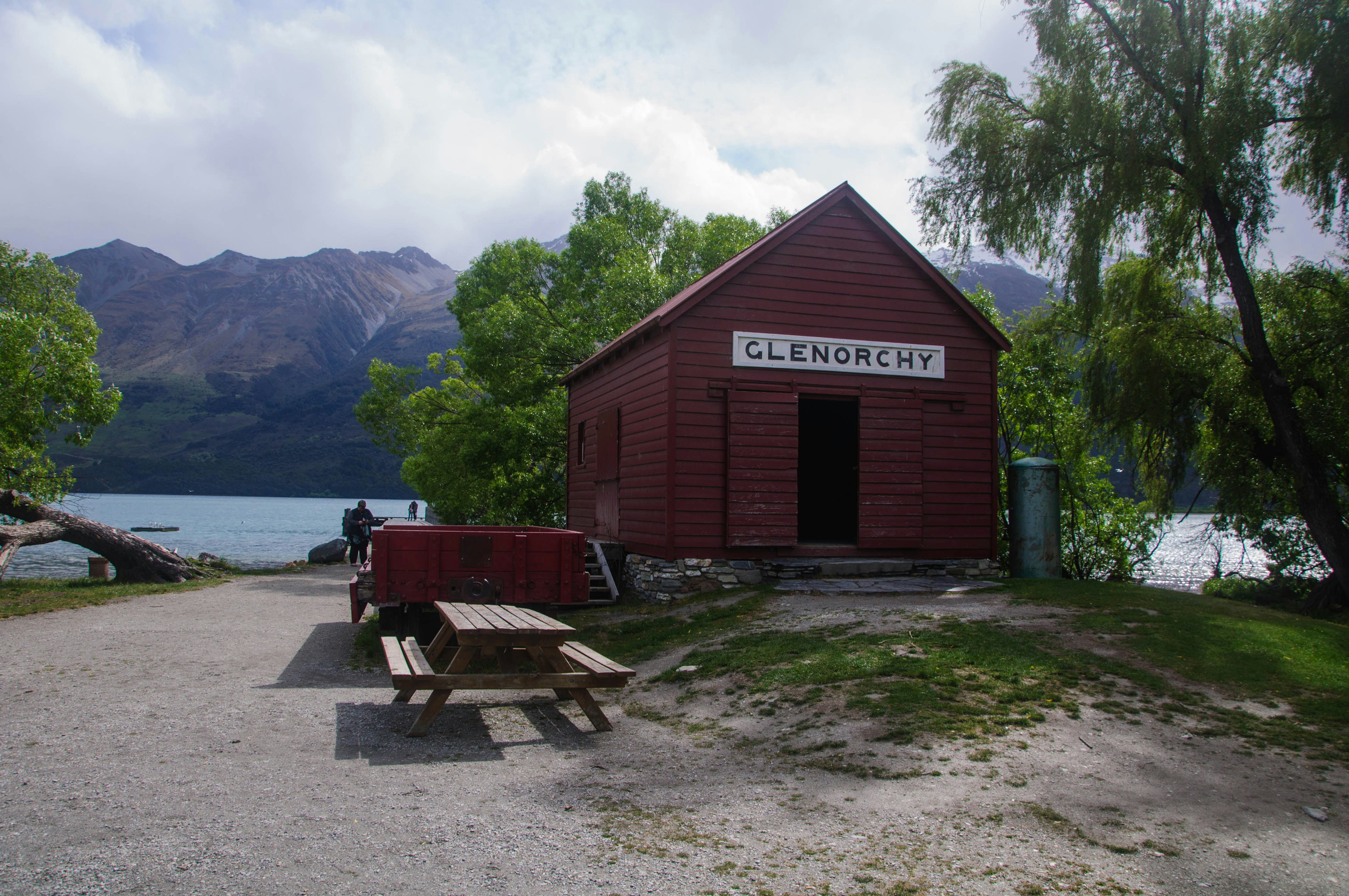 a picnic table and bench in front of a red building