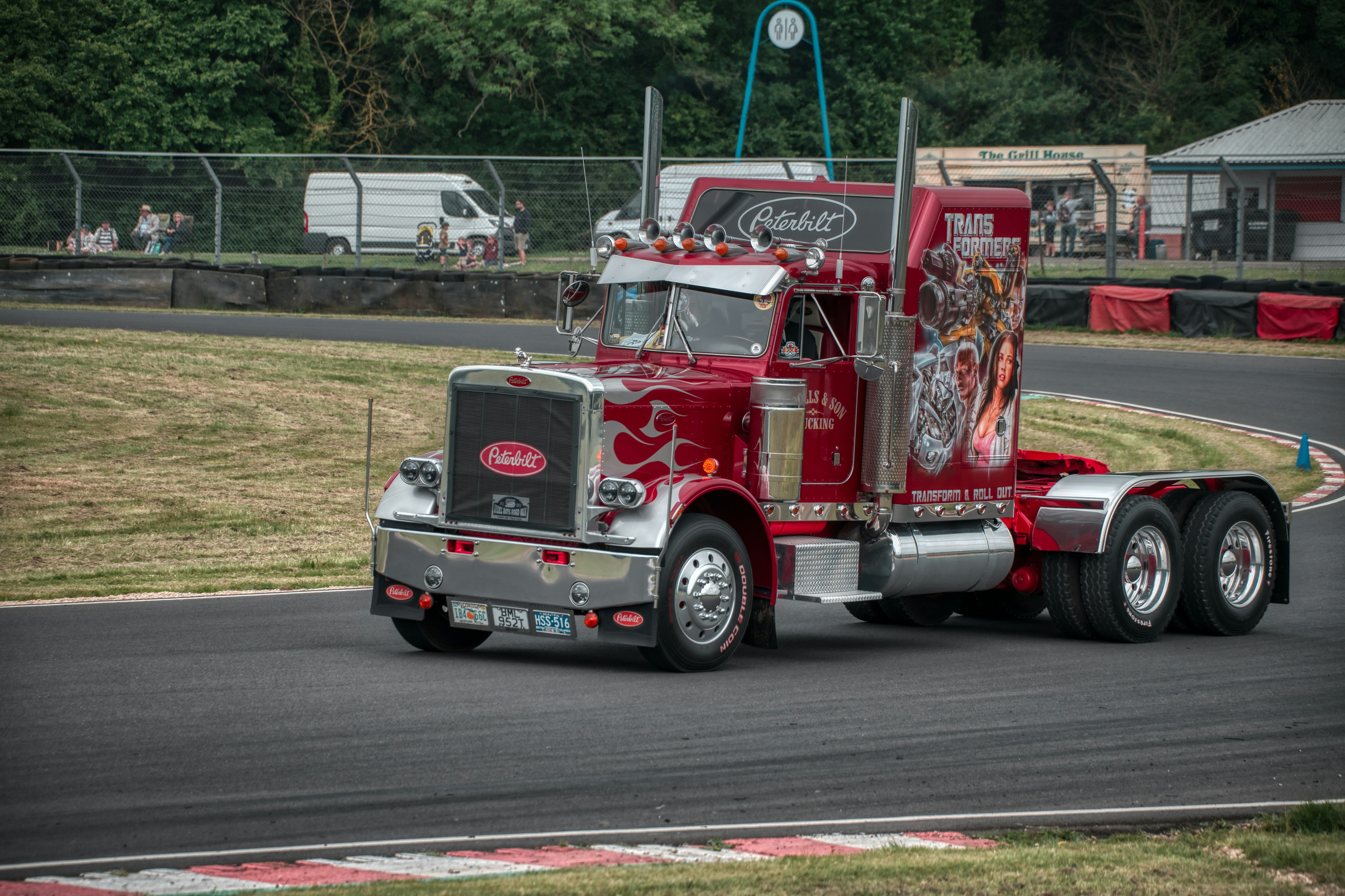 a red semi truck driving down a race track