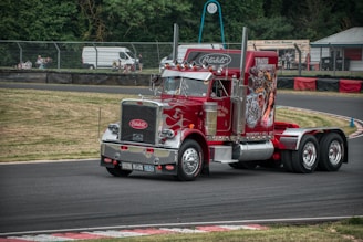 a red semi truck driving down a race track