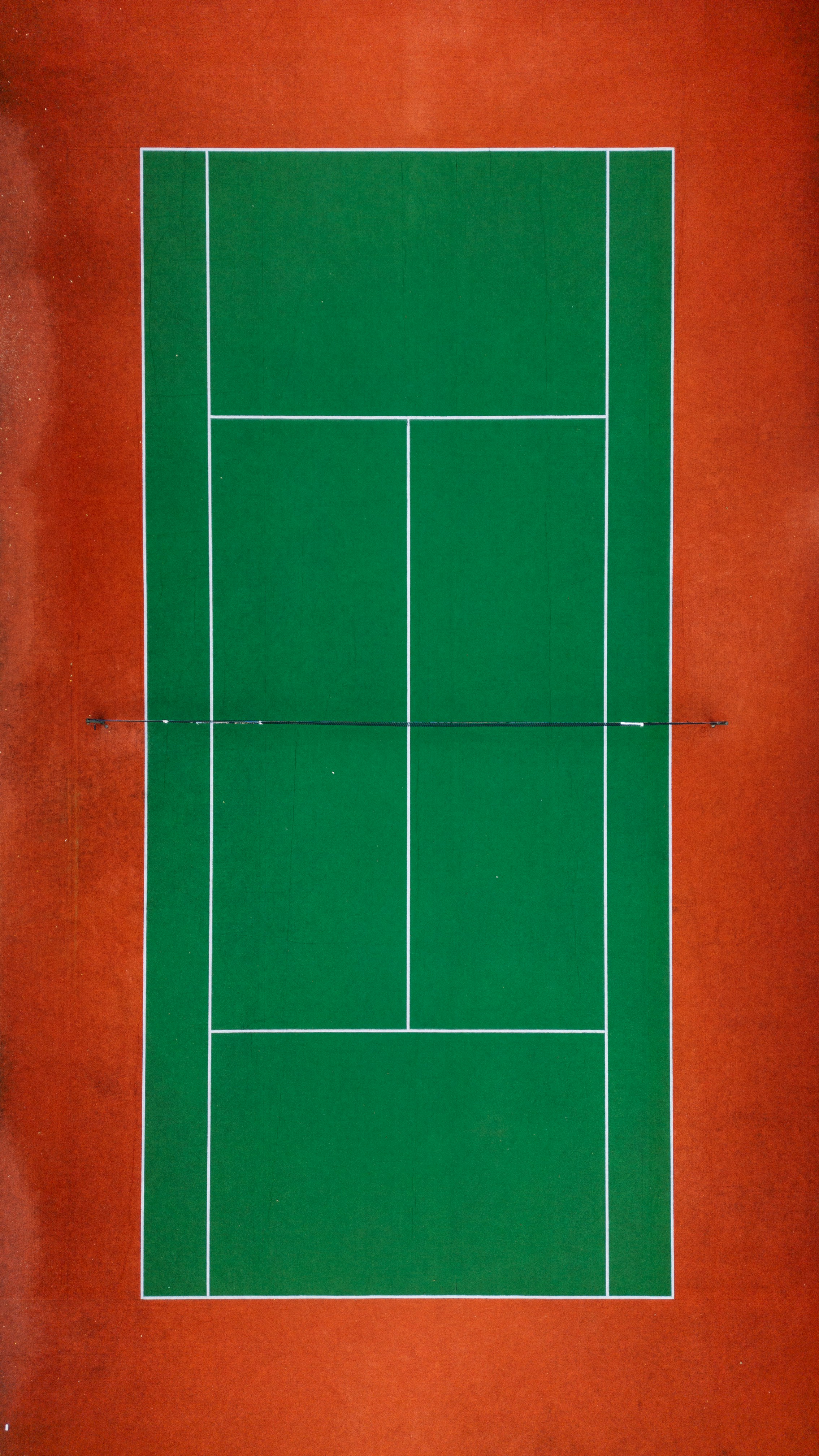 a green tennis court with a white line on it