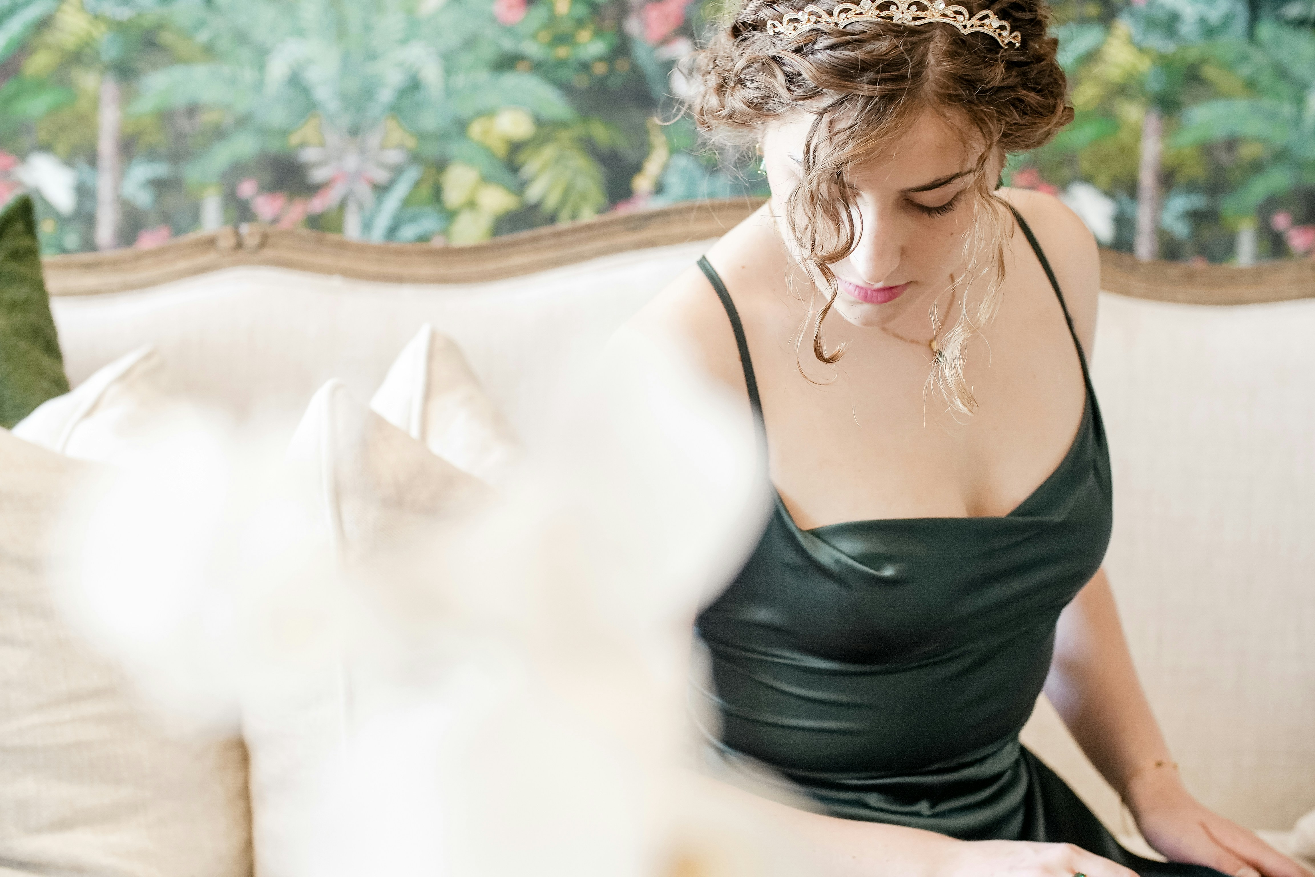 a woman sitting on a couch wearing a tiara