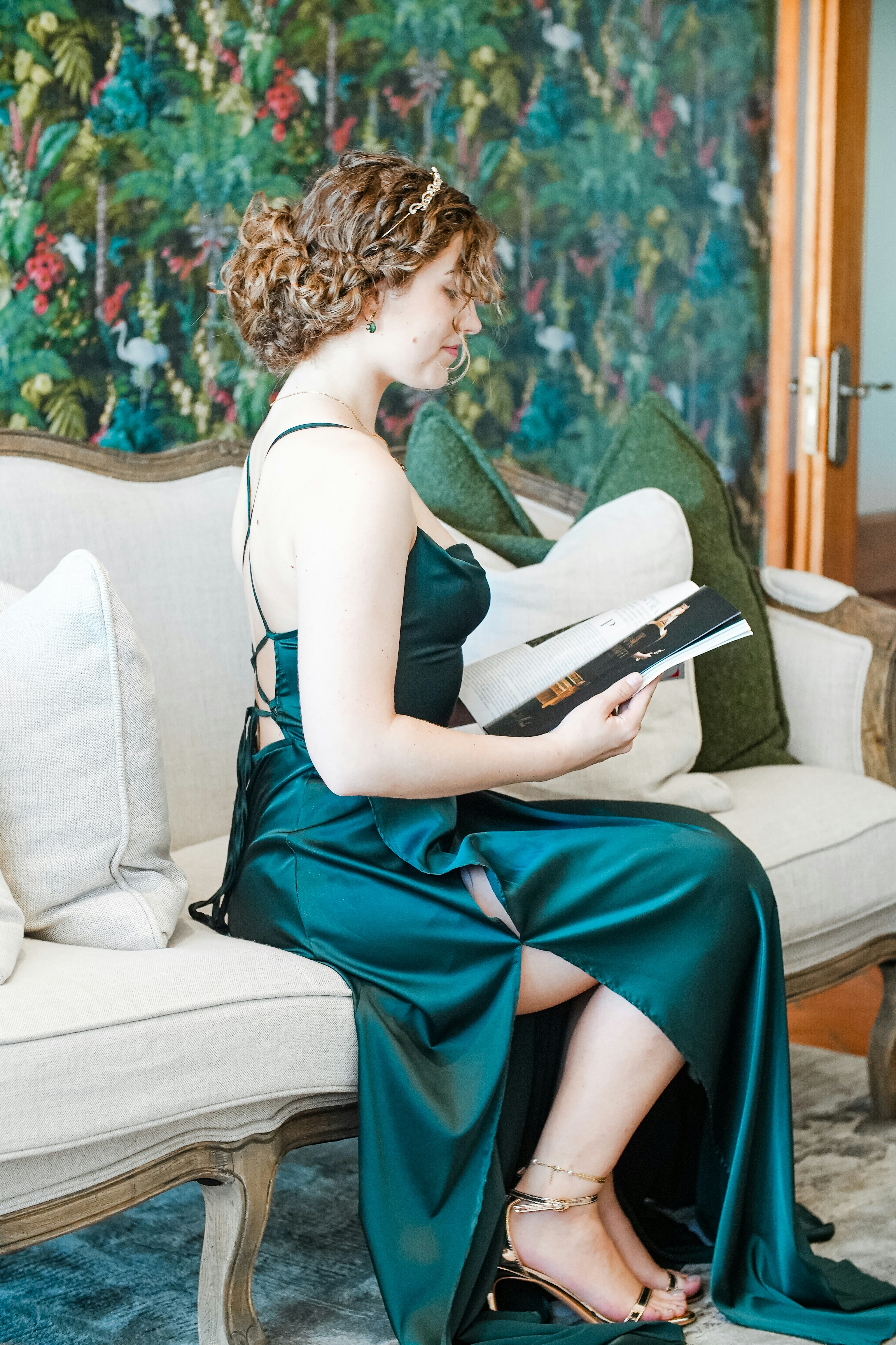 a woman sitting on a couch reading a book