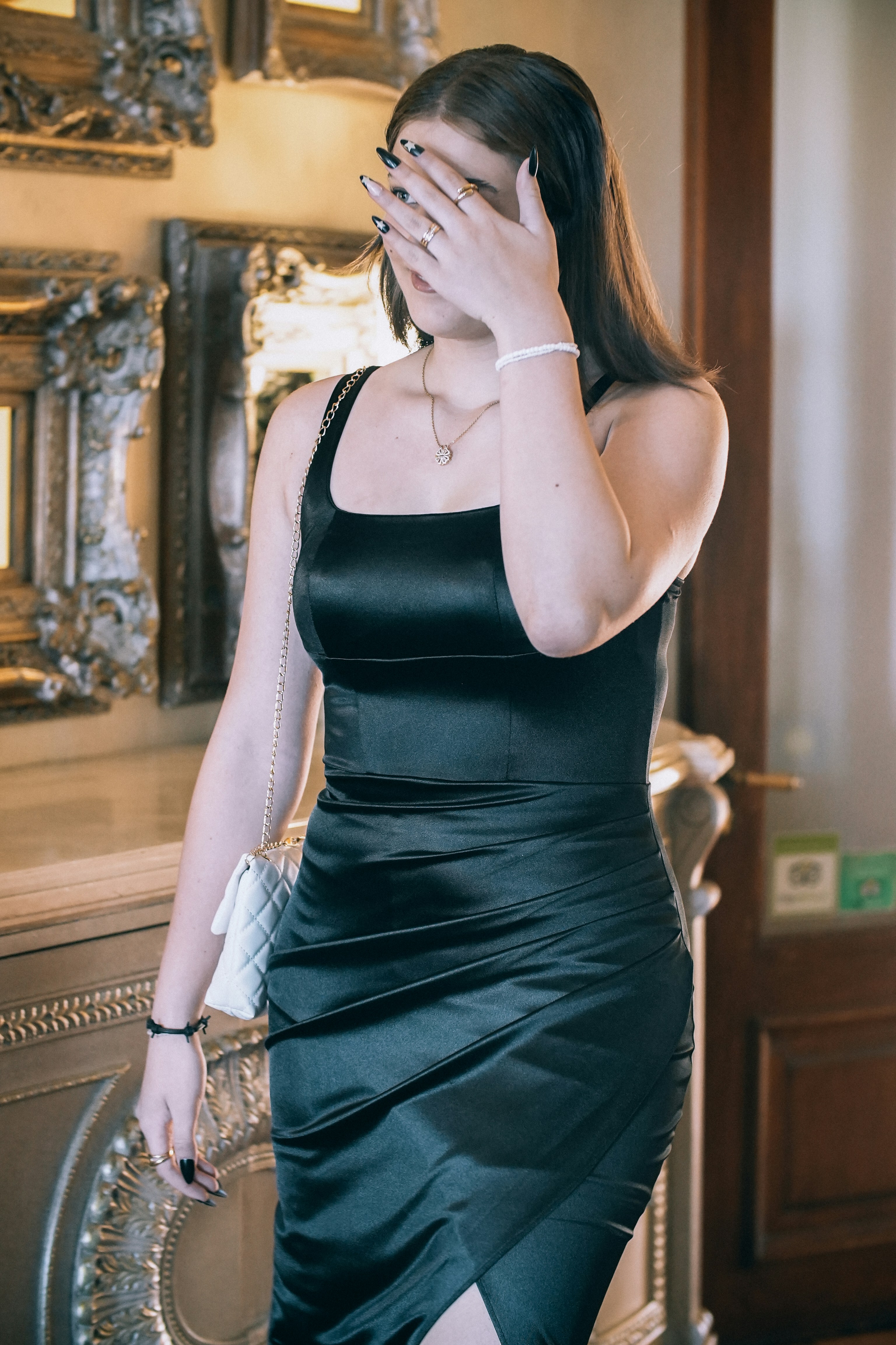 a woman in a black dress is covering her eyes