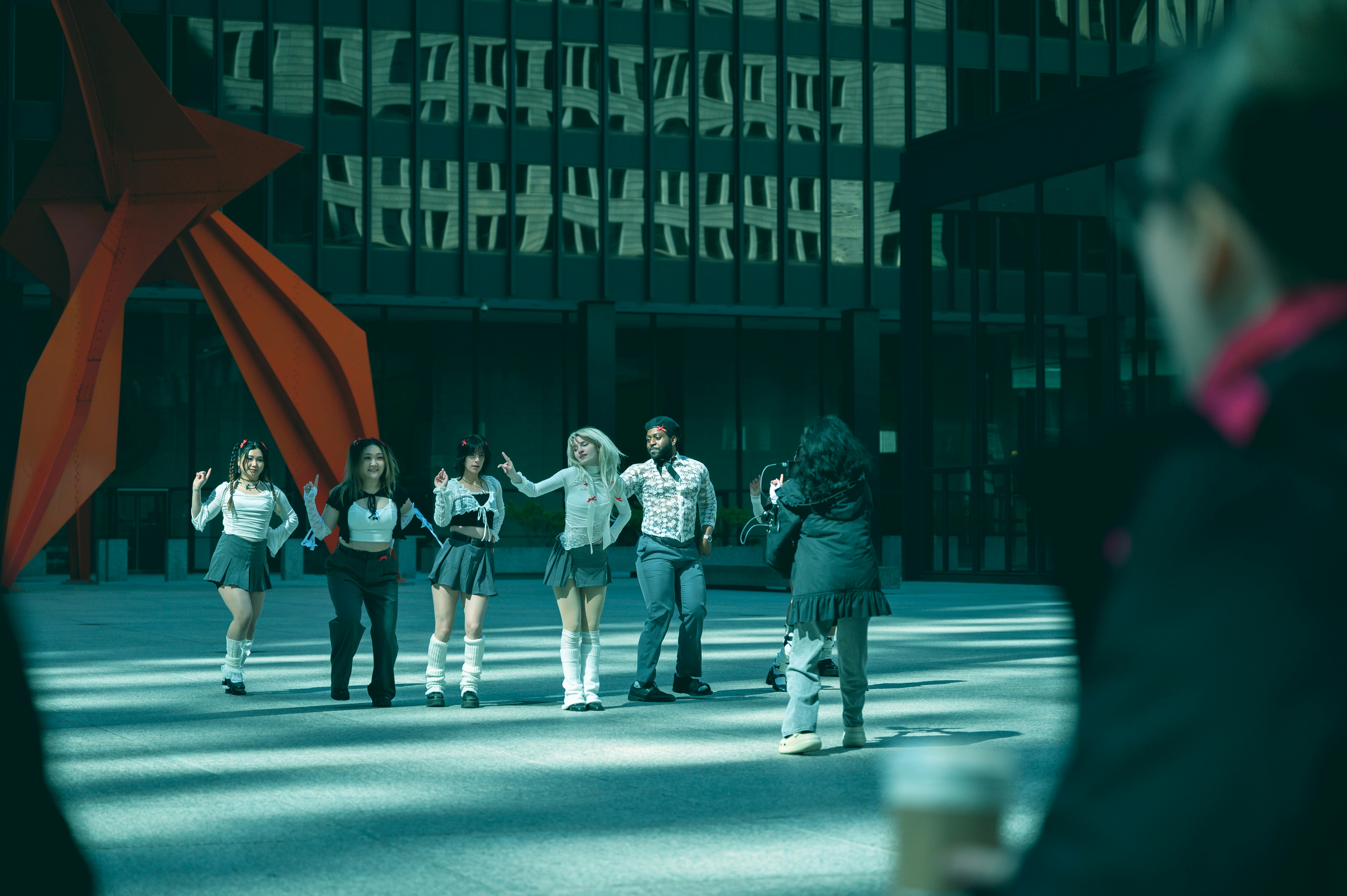 un gruppo di persone che camminano lungo una strada accanto a edifici alti