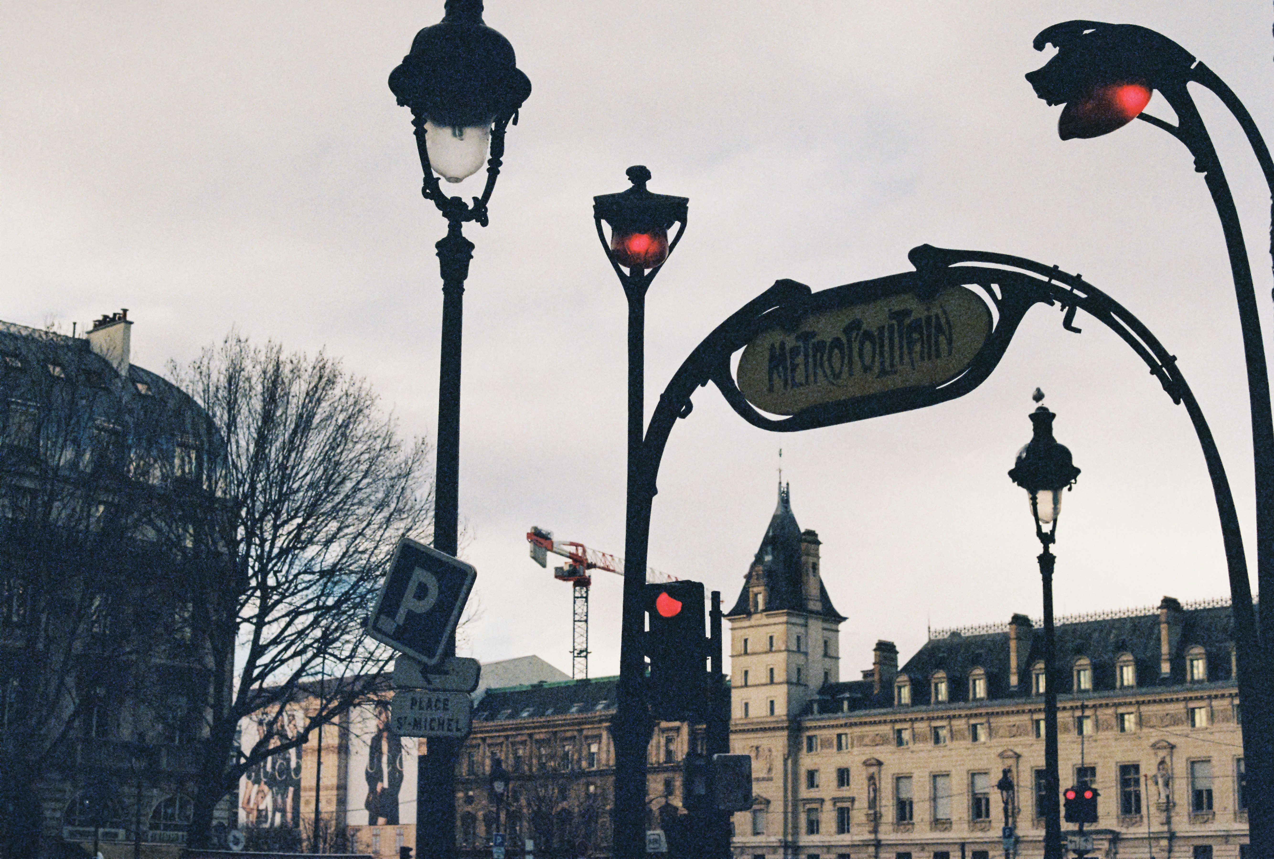 a group of street lights sitting next to a tall building