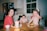 a couple of kids sitting at a table with plates of food