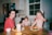 a couple of kids sitting at a table with plates of food