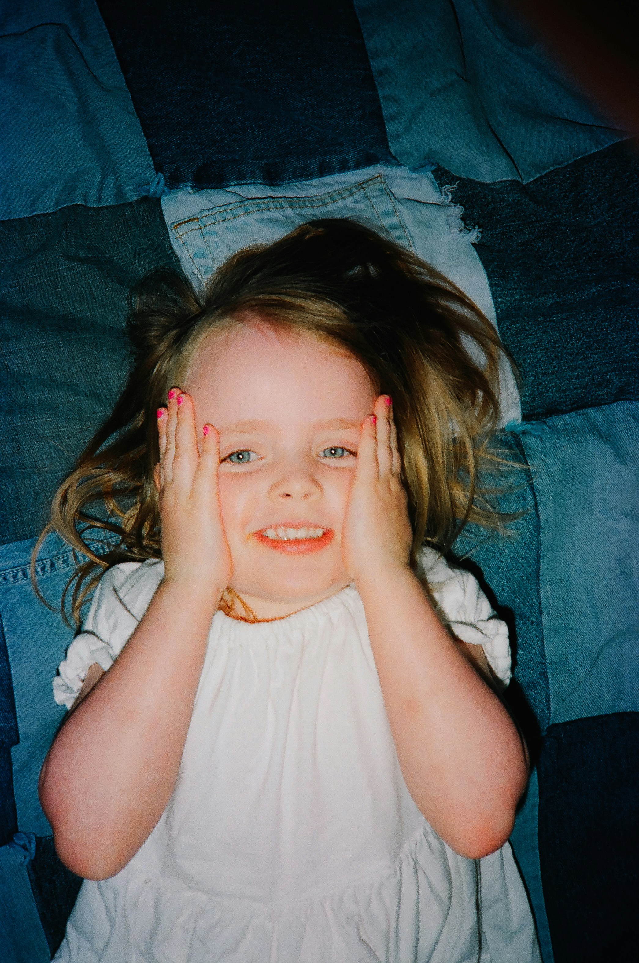 a little girl that is laying down on a bed