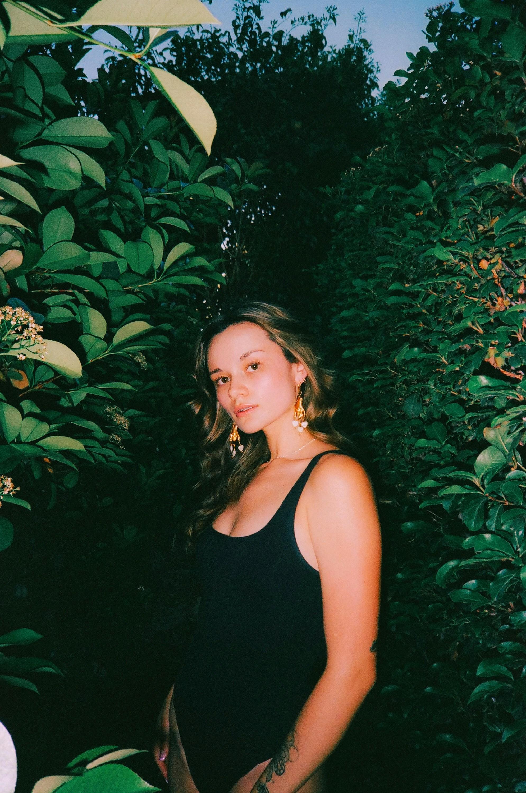 a woman standing in front of a bush