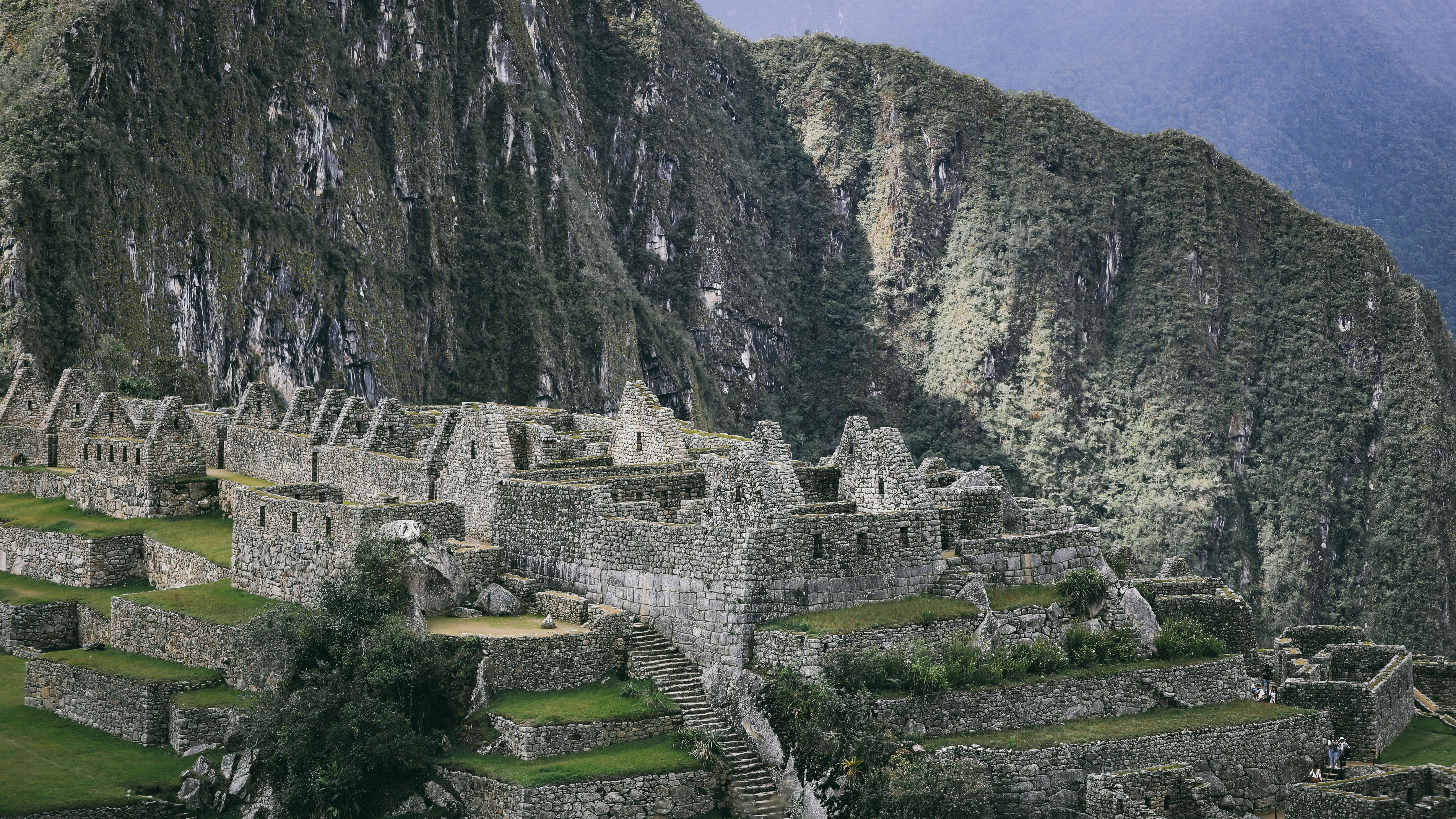the ruins of a mountain are surrounded by greenery, 