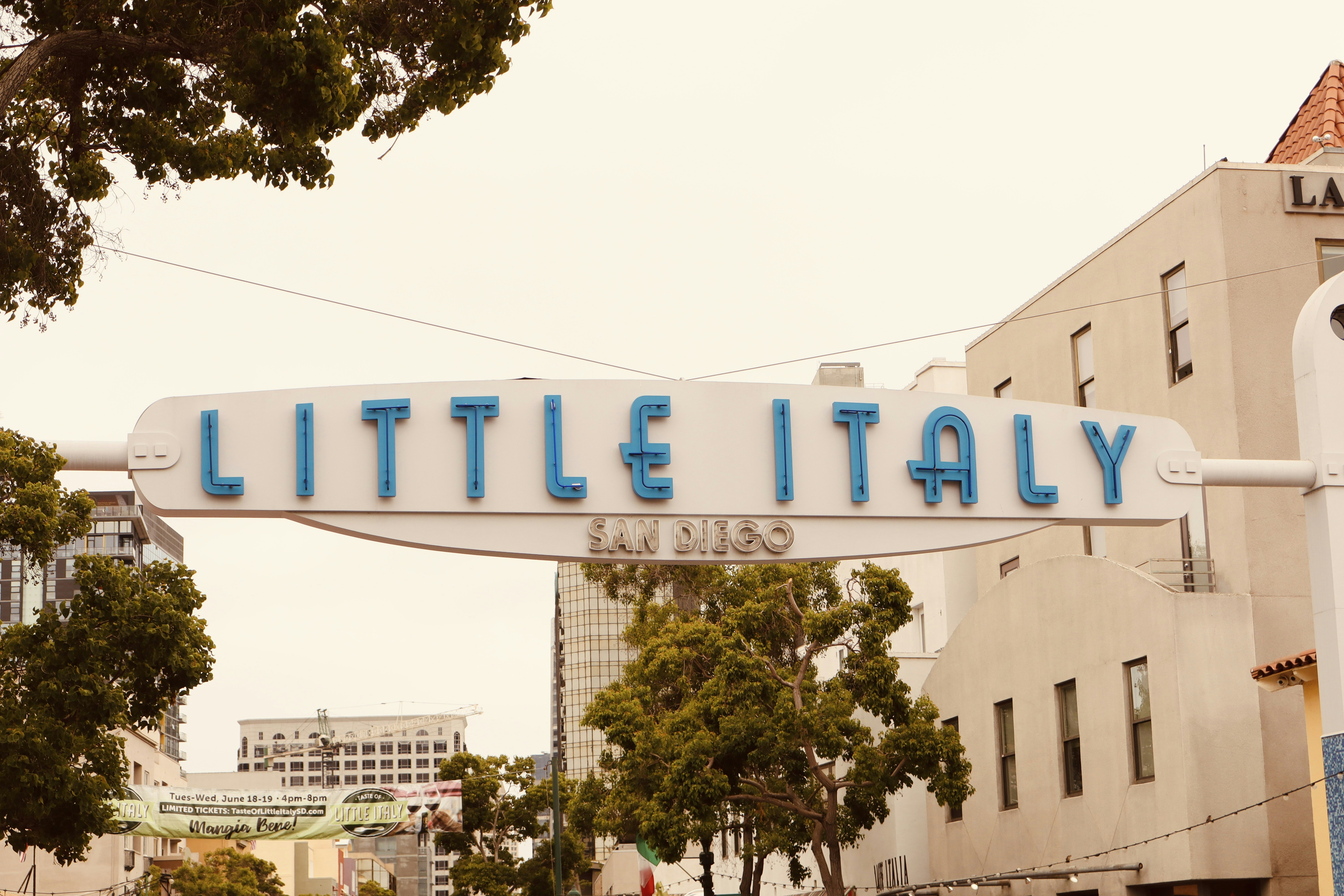 a sign that says little italy above a street