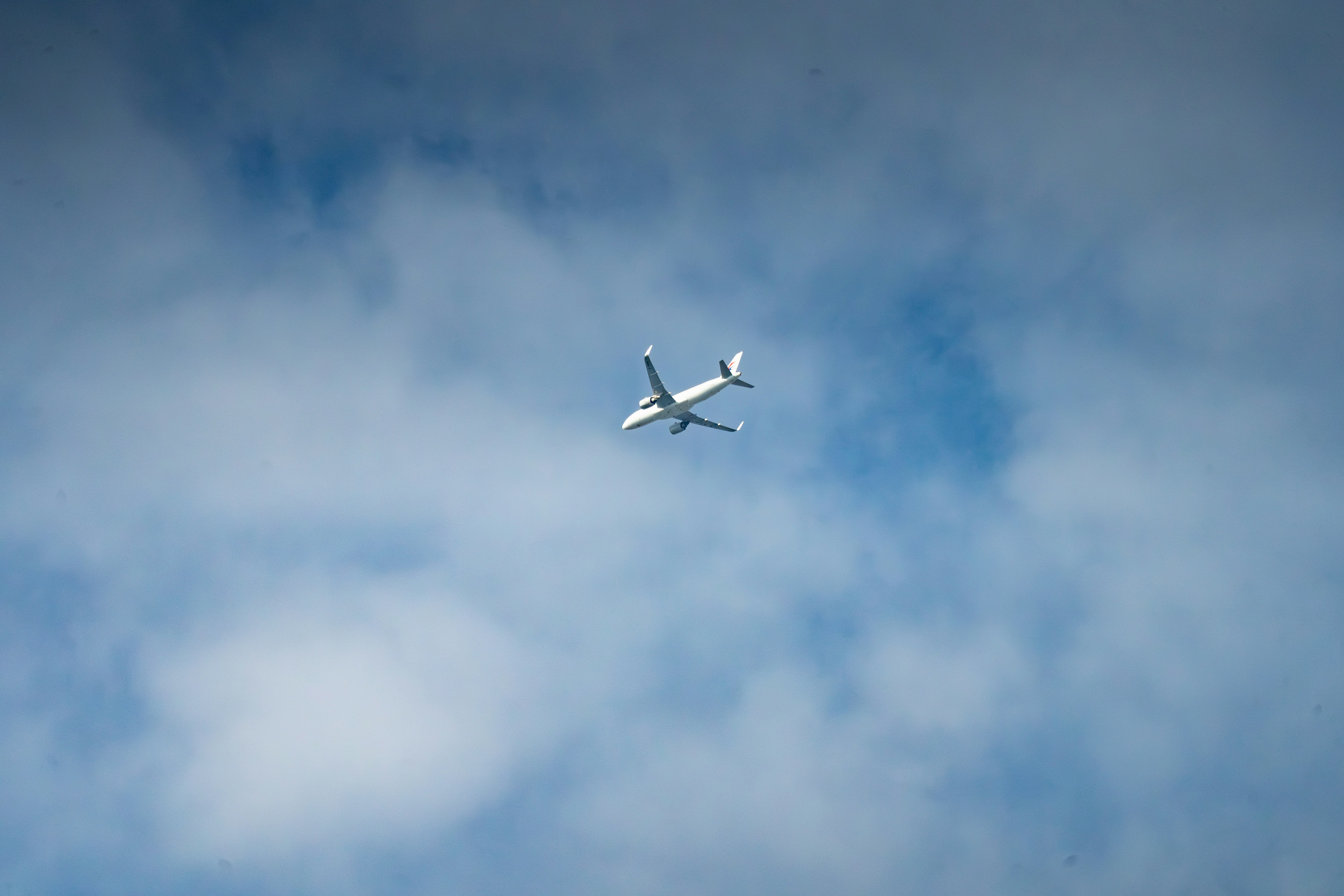 an airplane is flying in the sky on a cloudy day