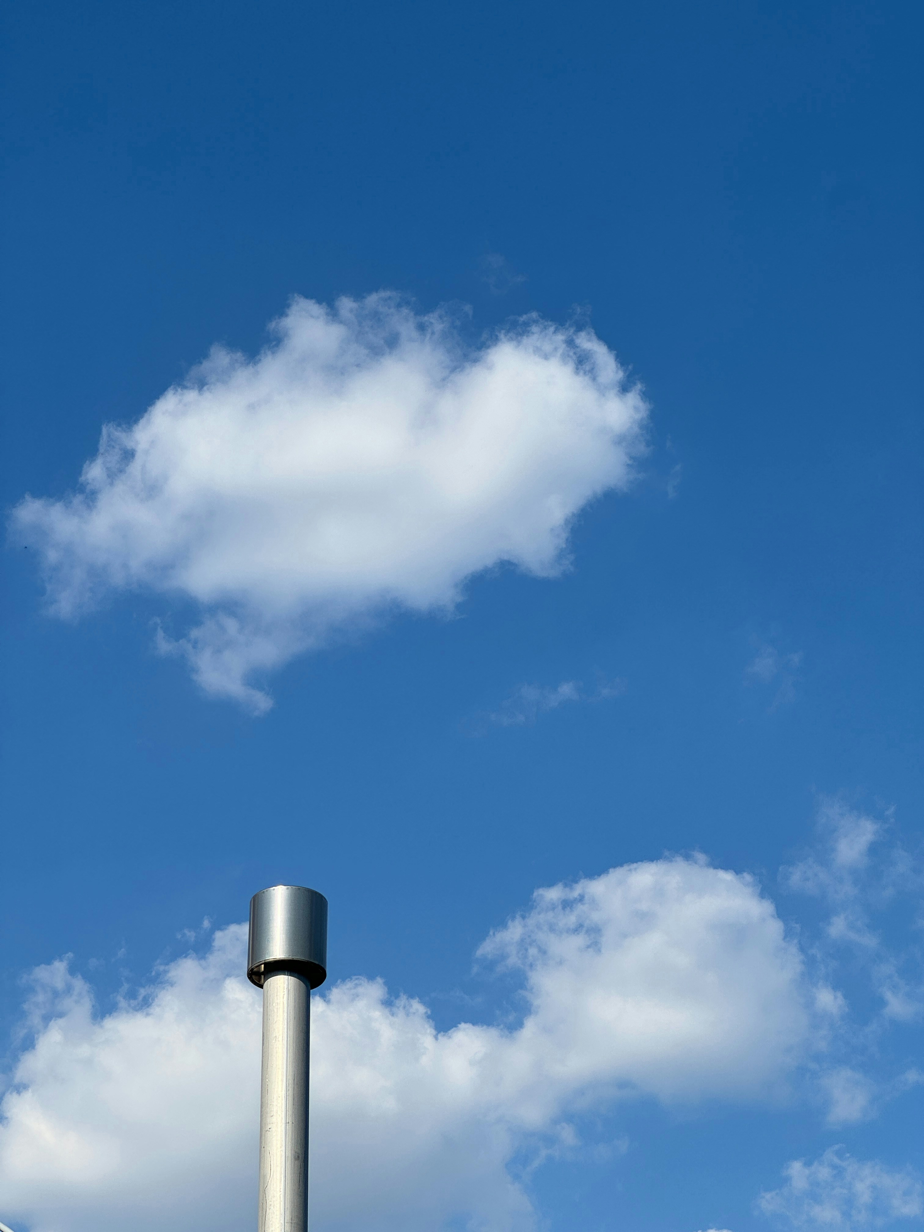 a tall metal pole with a sky background