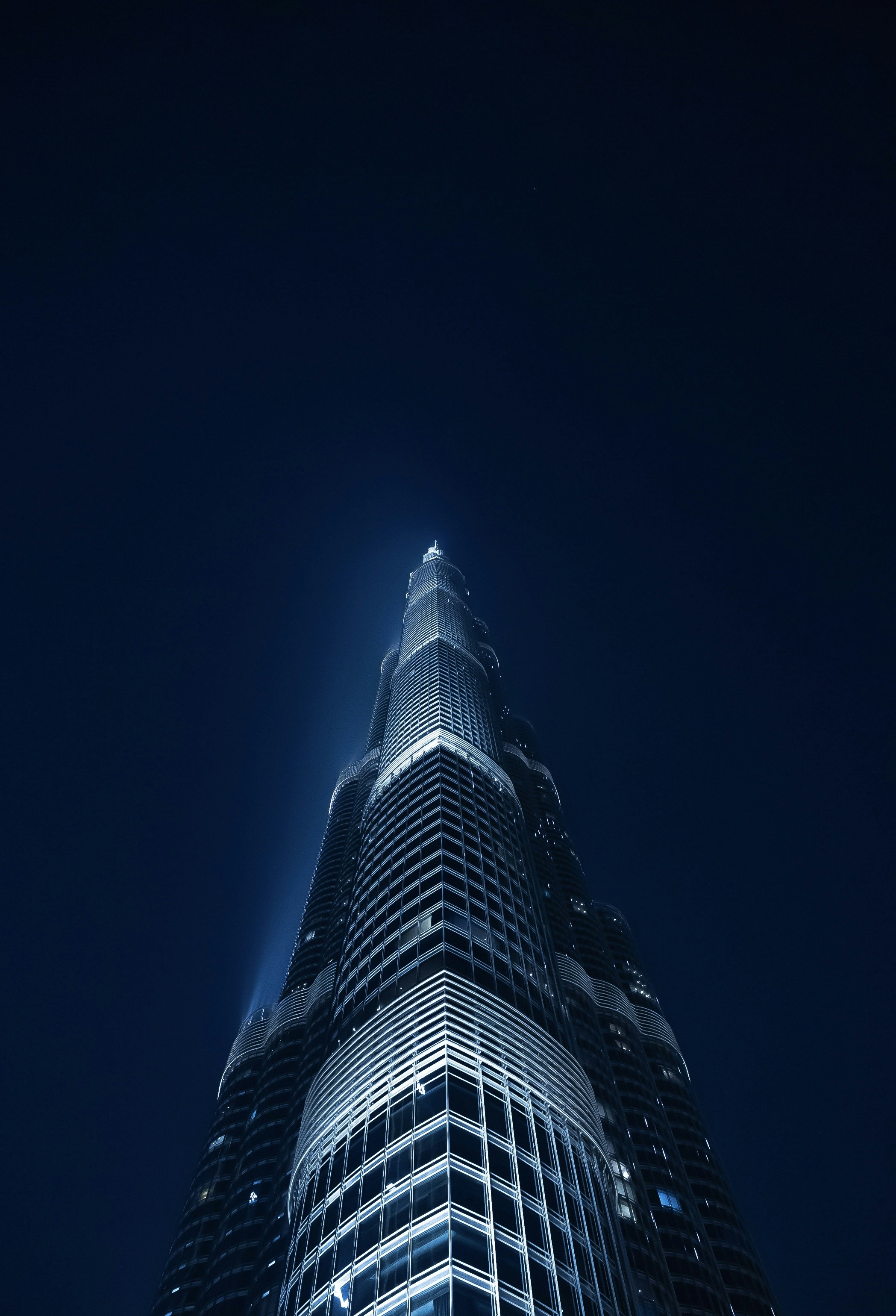 Dubai Burj Khalifa at night against dark blue sky with bright city lights below