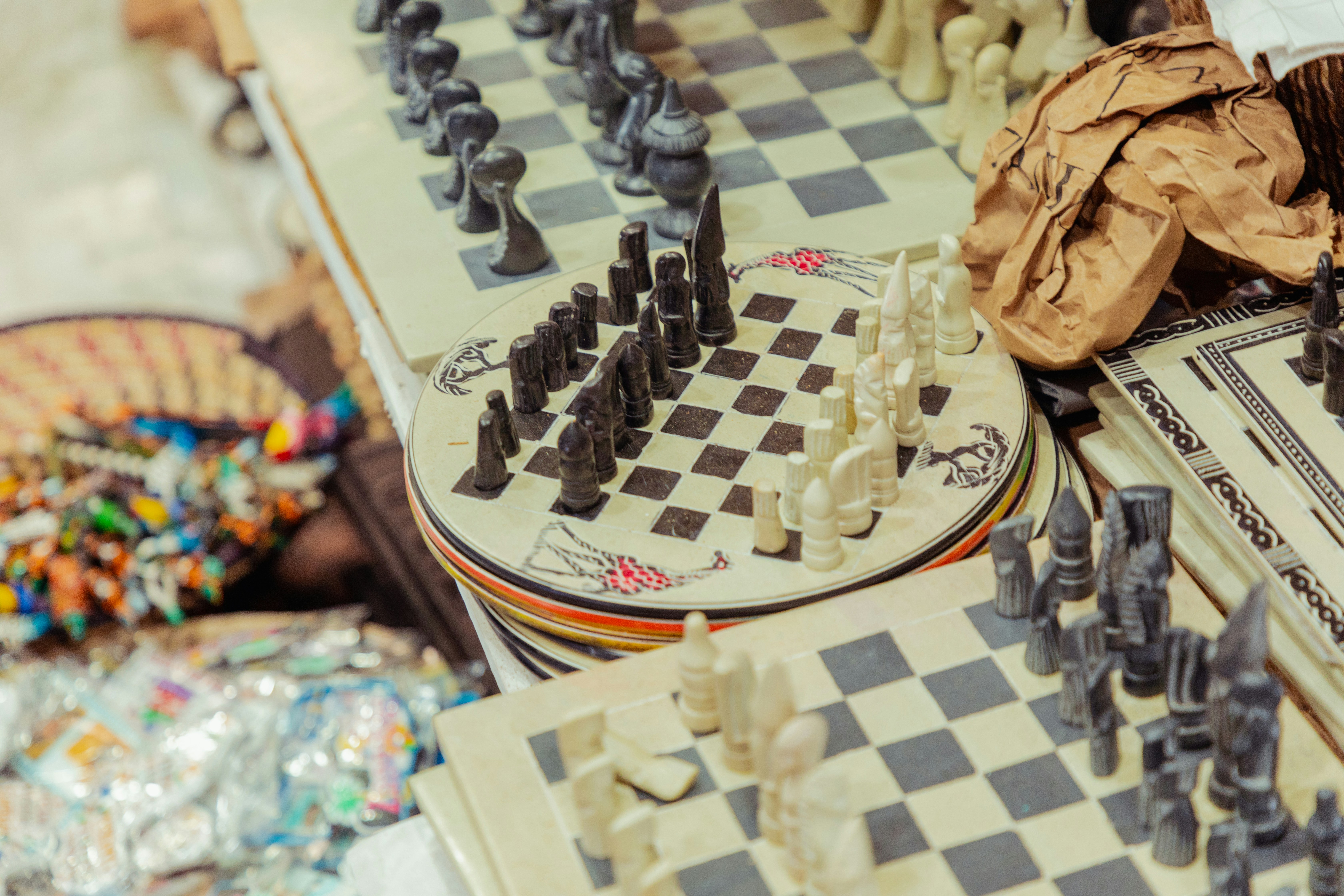 Chess pieces on boards on a cluttered table