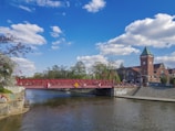 a bridge over a river with a clock tower in the background