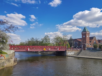 a bridge over a river with a clock tower in the background