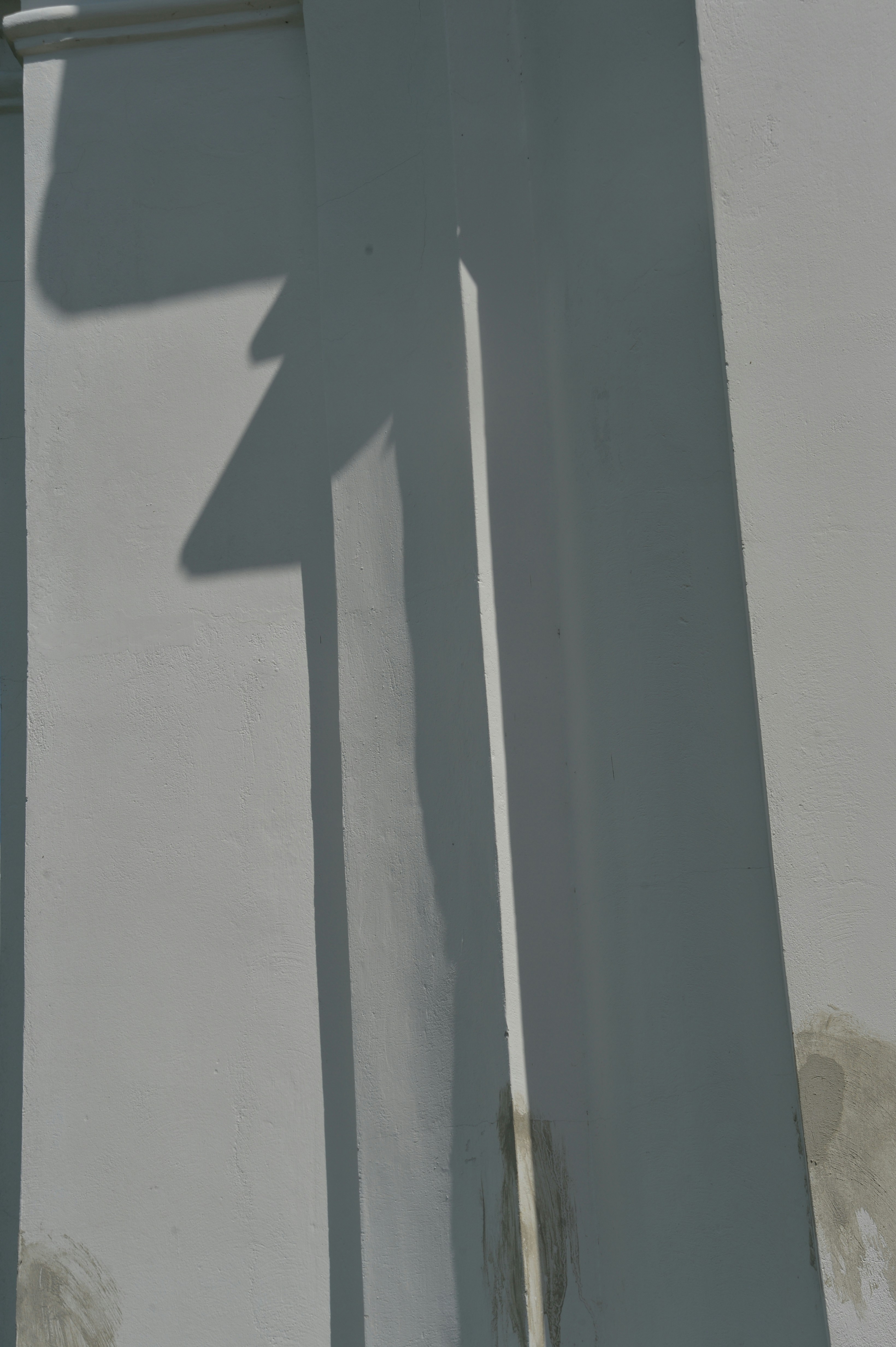 a shadow of a street sign on a white wall