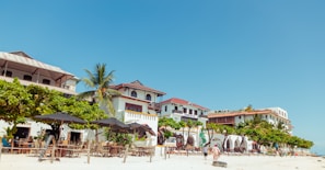 a group of people sitting at tables on a beach